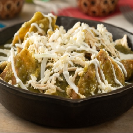 “Chilaquiles verdes served with green salsa, drizzled cream, and crumbled fresh cheese.”