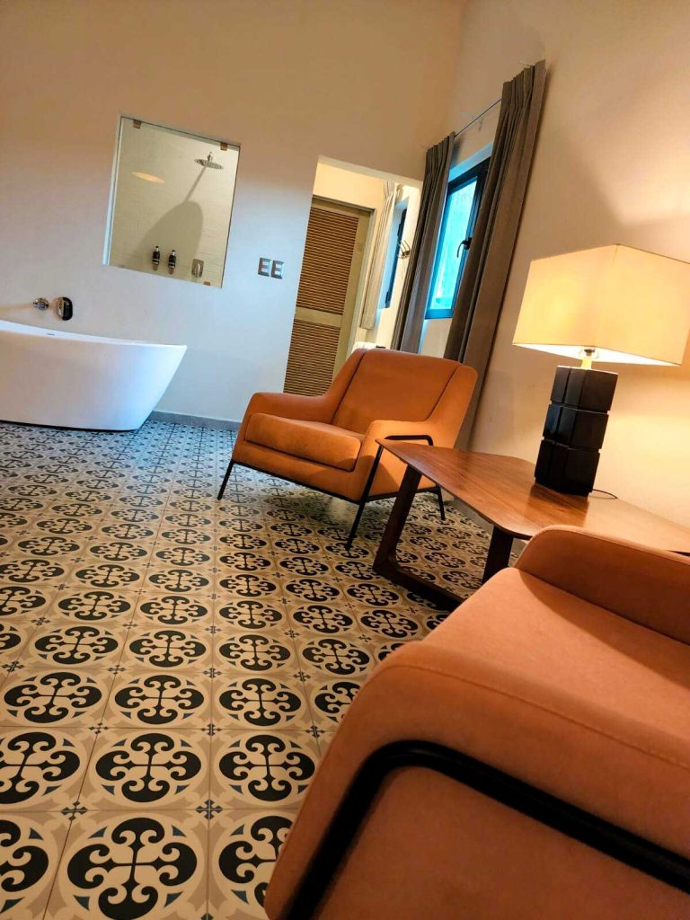 "Elegant room corner with in-room bathtub and shower window facing the bedroom."