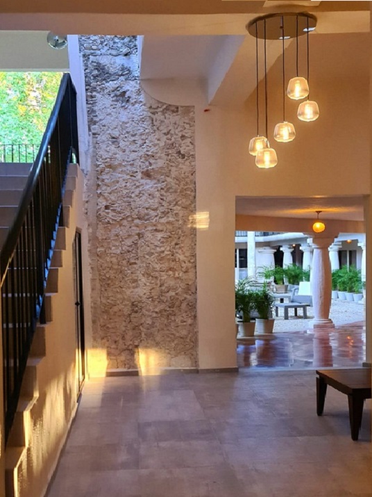 “Stone wall in a Yucatán hotel lobby, showcasing traditional local architecture and a relaxing atmosphere.”